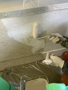 練馬区N様邸 外壁塗装工事 凹凸のある壁面に柔らかいローラーで塗装する様子